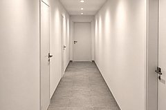 Zentraler Flur mit grauen Betonfliesen
